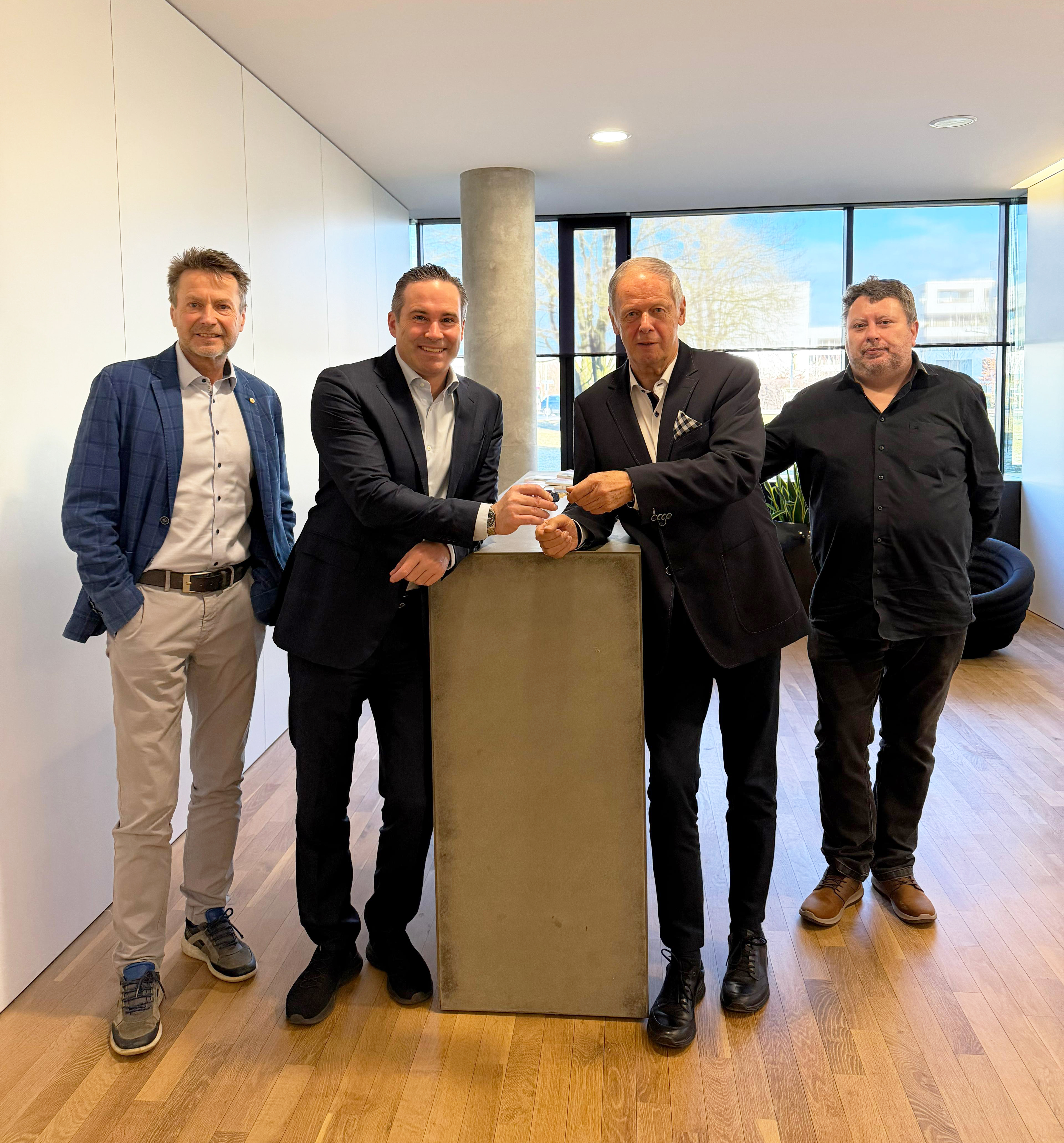 Former owners Günther Lindinger (second from right) and Helmut Feichtinger (far right) hand over the keys to TFM to Mario Haidlmair (second from left) and Günther Hitzl, M&A manager of the Haidlmair Group (far left). (Photo: Haidlmair)